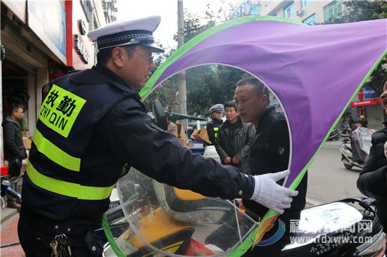 交警依法收缴部分市民在电动车上违规安装的遮雨盖。.jpg