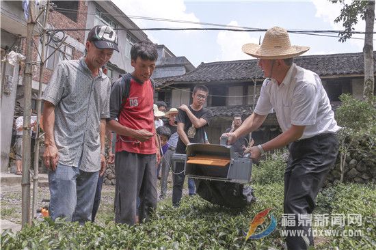 蔡梅生（右一）指导两家贫困户使用农机设备.jpg