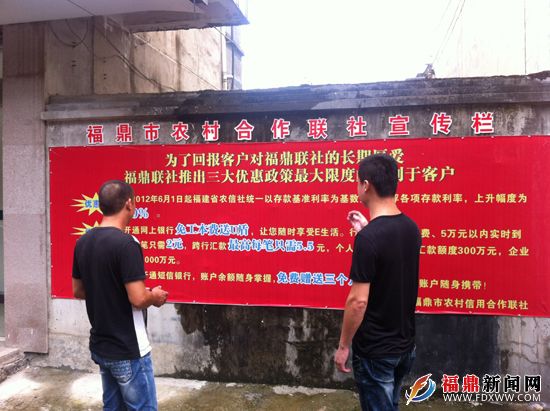 图为群众观看福鼎市贯岭镇贯岭村福鼎联社宣传栏优惠广告.jpg
