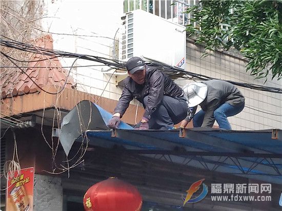 工作人员正在拆除违章搭盖雨披.jpg